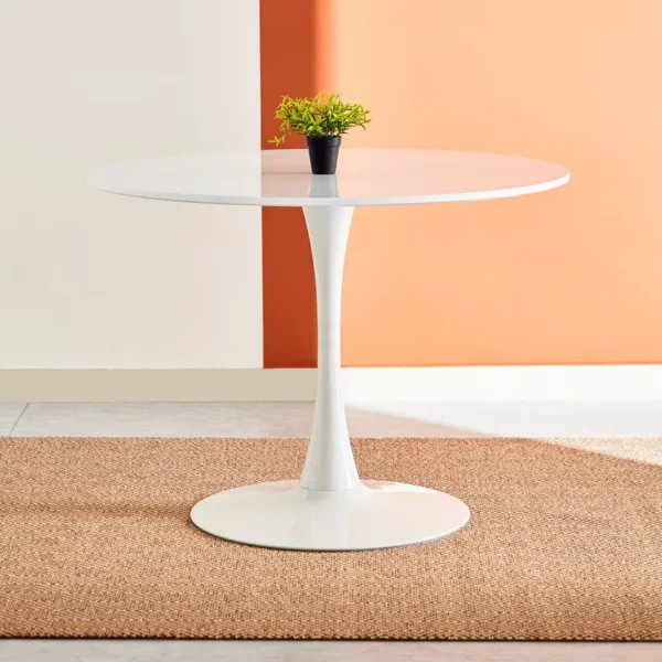 A stylish white round dining table with a smooth matte finish and tapered legs, set in a cozy dining room.