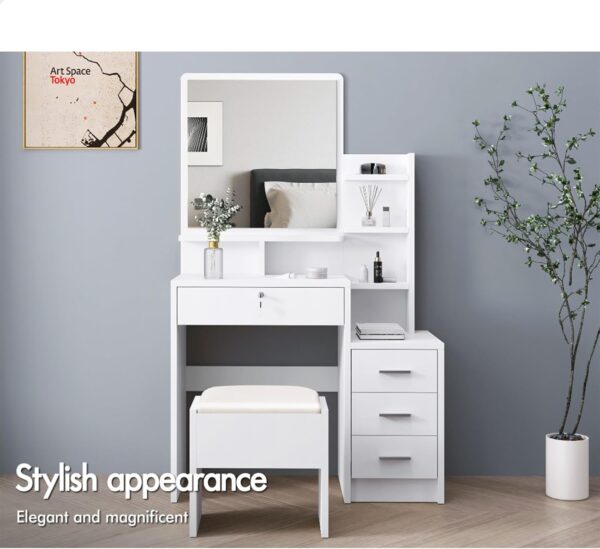 "White dressing table with a matching stool, featuring sleek lines and a modern design, set against a light-colored wall."