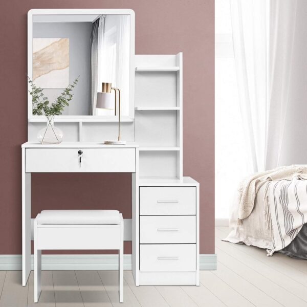 "White dressing table with a matching stool, featuring sleek lines and a modern design, set against a light-colored wall."