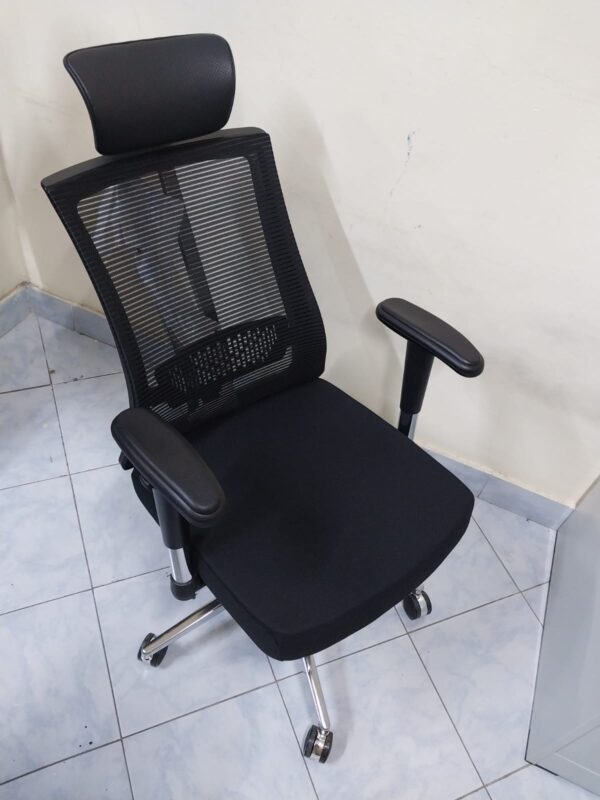 Black Orthopedic Seat with Lumbar Support placed in a modern office setting, showcasing its ergonomic design.