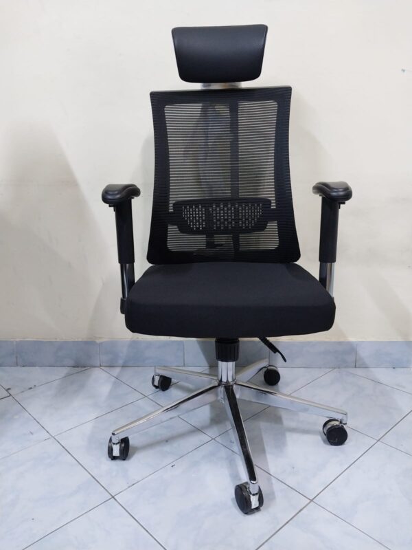 Black Orthopedic Seat with Lumbar Support placed in a modern office setting, showcasing its ergonomic design.